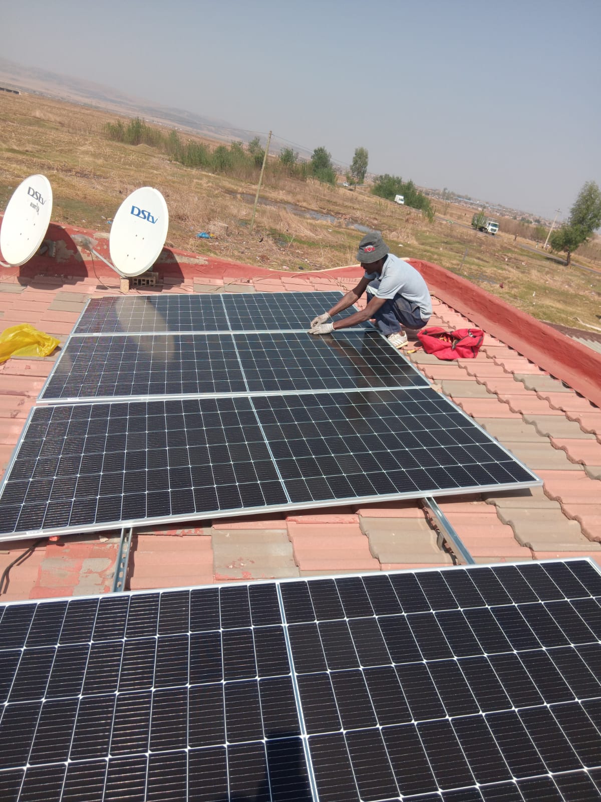 Full solar array on residential tile roof with DStv dishes